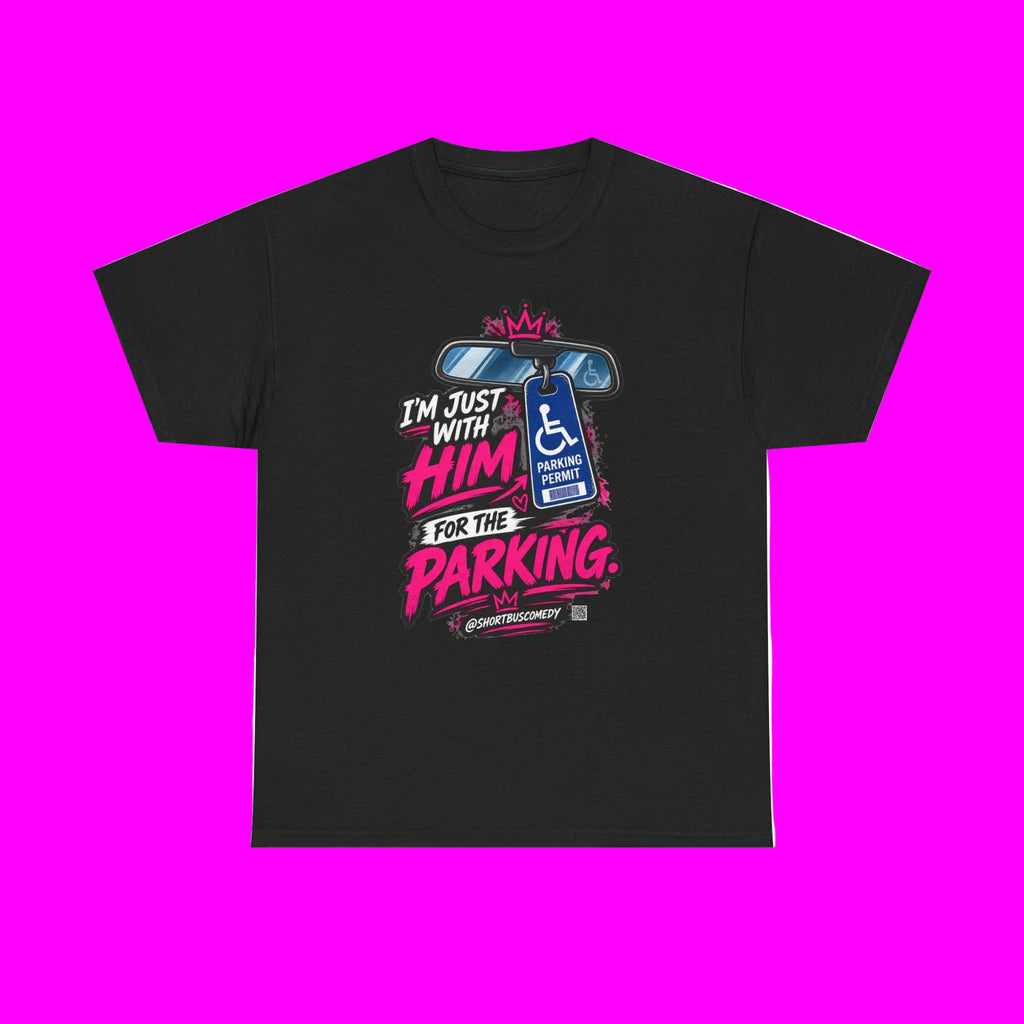 A black short-sleeve crewneck t-shirt with a colorful graphic on the front. The graphic features a blue handicap parking symbol with a wheelchair, a pink crown, and bold pink and white text that reads 'I'M JUST WITH HIM FOR THE PARKING.